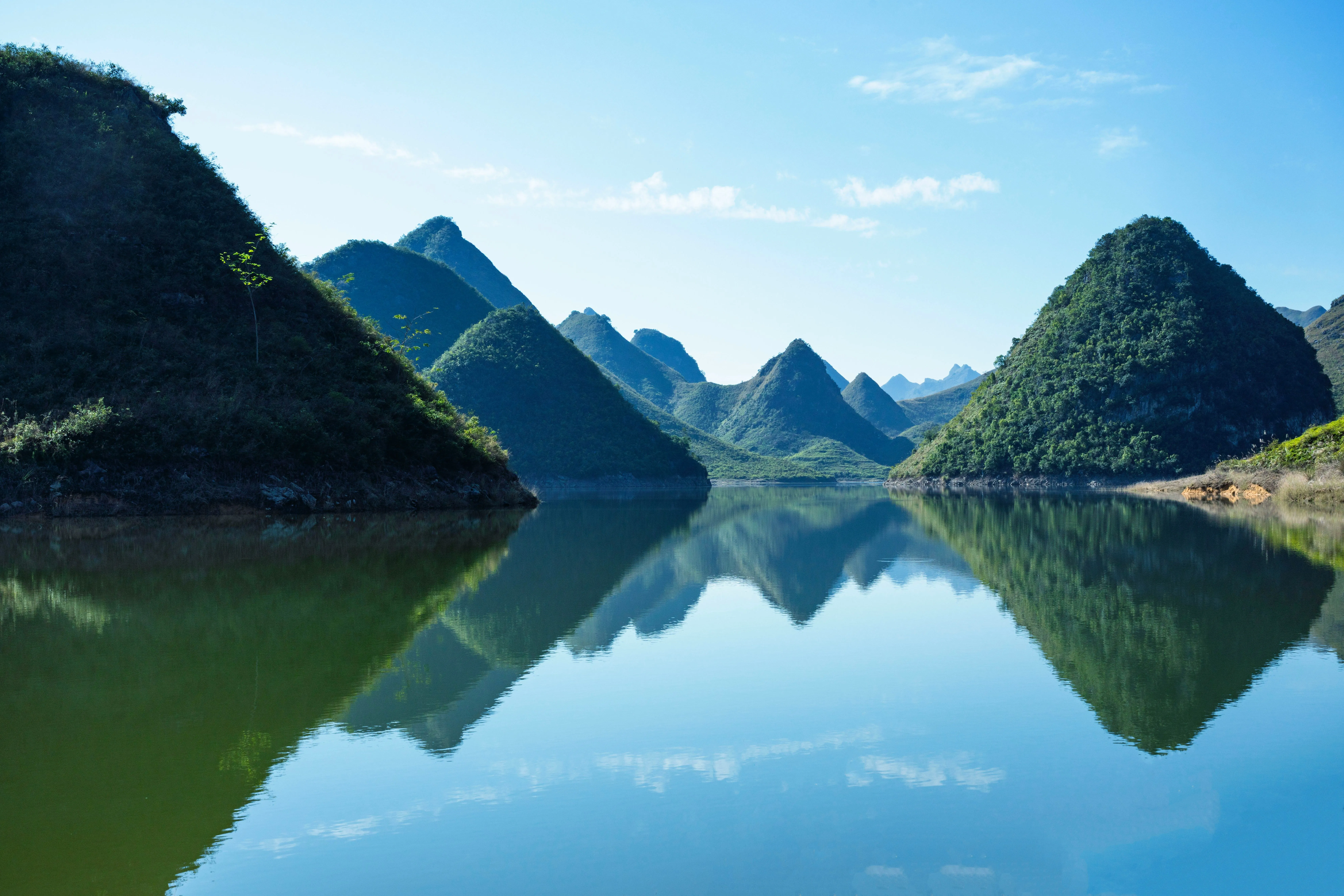 Pointed mountains reflected in surface of calm lake