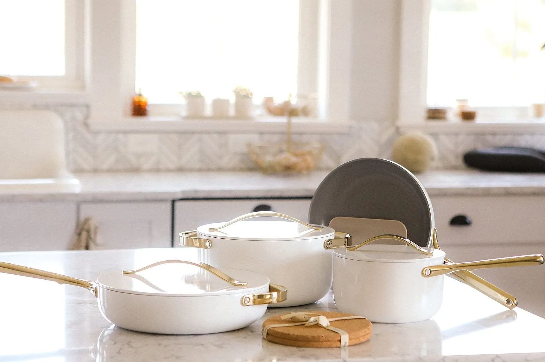 White pots and pans on kitchen countertop.